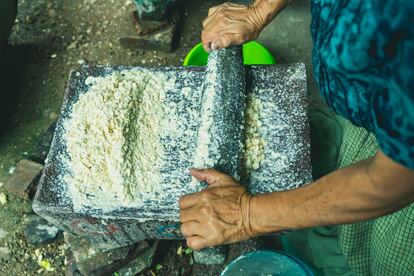 Una mujer amasa elote en Oaxaca.