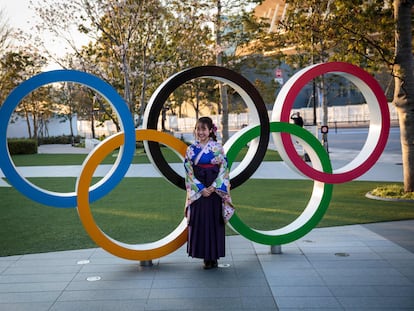 Una mujer japonesa, vestida con un kimono, ante los aros olímpicos en Tokio.