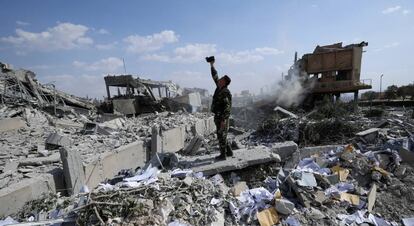 Soldado sírio filma os destroços após o bombardeio aliado.