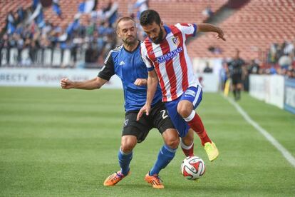 Brandon Barklage disputa un bal&oacute;n con Arda Turan.