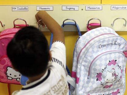 Un alumno coloca su mochila en su colegio.