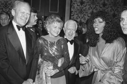 La cantante Donna Summer charla con el expresidente Ford y su esposa Betty, durante una gala benéfica celebrada en noviemre de1979.