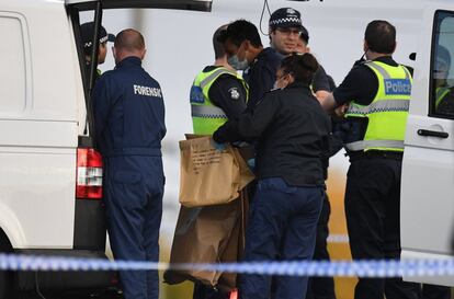 Policía Forense lleva una bolsa de evidencia que dice "libro de carátula dura en árabe" frente a los Buckingham Serviced Apartments en Brighton en Melbourne (Australia).