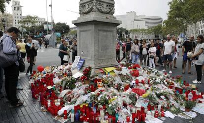 Barceloneses y turistas hacen un alto en el Memorial con flores a las v&iacute;ctimas del atentado terrorista, situado al comienzo de las Ramblas de Barcelona.