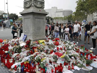 Barceloneses y turistas hacen un alto en el Memorial con flores a las v&iacute;ctimas del atentado terrorista, situado al comienzo de las Ramblas de Barcelona.