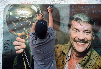 Un fan escribe un mensaje de despedida en un muro homenaje a Jerry Buss a las puertas del teatro Nokia.
