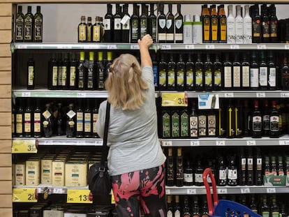 Una clienta de un supermercado español elige una botella de aceite de oliva.