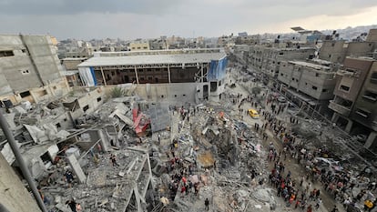 Un grupo de palestinos rodean un edificio derrumbado tras un ataque israelí en el campo de refugiados de Yabalia, en el norte de Gaza, este martes. 