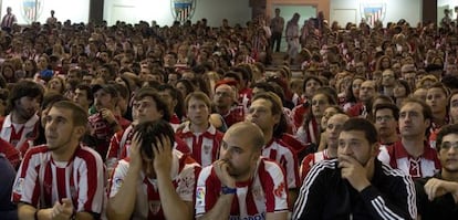 Seguidores del Athletic observan el partido con gesto de preocupación.