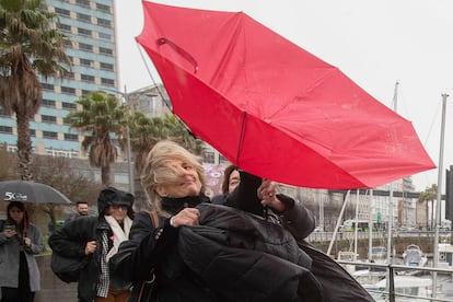 La vicepresidenta del Gobierno y líder del movimiento Sumar Yolanda Diaz (centro) y la candidata de Sumar a la Presidencia de la Xunta de Galicia Marta Lois (derecha) tratan de enderezar el paraguas a su llegada a la villa de Cangas de Morrazo (Pontevedra), el 9 de febrero. 
