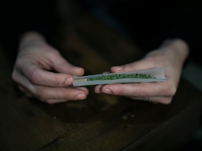 Una persona lía un porro de marihuana.