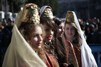 Mujeres vestidas con trajes tradicionales palestinos participan en una procesión de Navidad en la Plaza del Pesebre, en frente de la Iglesia de la Natividad, el lugar venerado como el lugar de nacimiento de Jesús, en la ciudad cisjordana de Belén.