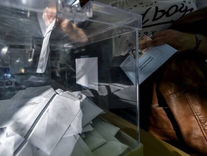 Una mujer introduce su voto en una urna en Girona.