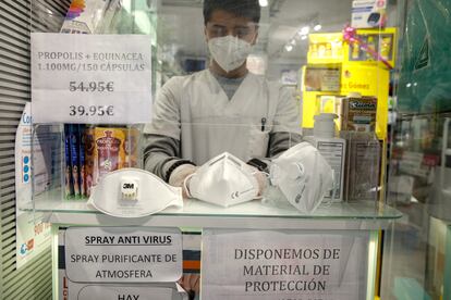 Un empleado de una farmacia despliega mascarillas FFP1, izquierda, FFP2, centro y FFP3, derecha, en una farmacia en Madrid.