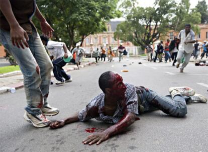 Un herido intenta huir de la zona donde las fuerzas de seguridad malgaches han abierto fuego contra los manifestantes que protestaban contra el Gobierno.