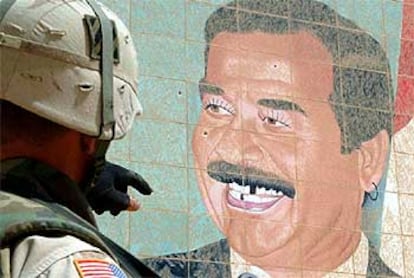 Un soldado observa un retrato de Sadam.