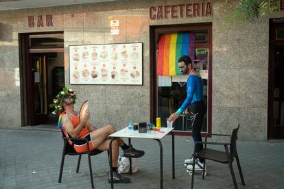 Dos personas descansan antes de la manifestación del Orgullo en Madrid.
