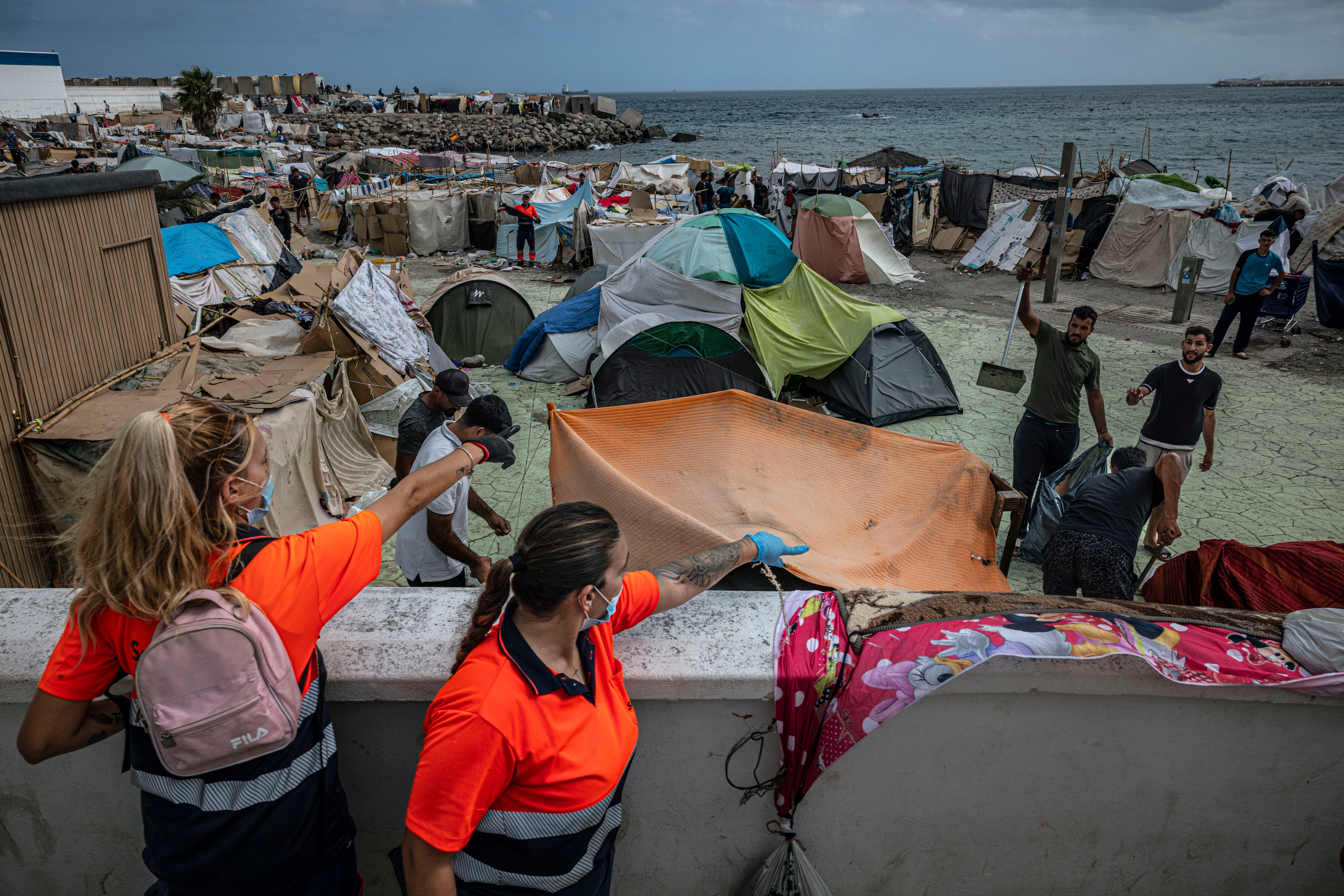 Unos operarios de limpieza de Ceuta junto al asentamiento de la playa de Benítez. 
