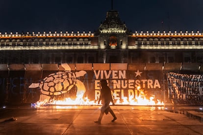 Manifestantes prenden fuego a las vallas que cubren Palacio Nacional durante la manifestación de este jueves.