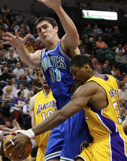 El jugador de los Lakers Ron Artest lucha por el control de un balón con el de Minnesota Darko Milicic