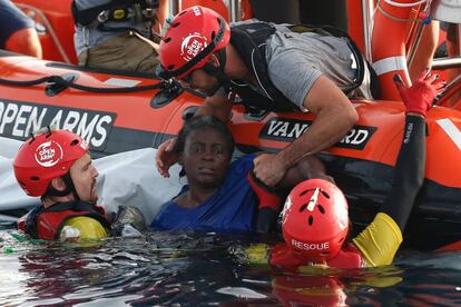 Miembros de Open Arms sacan del agua a la mujer que se aferraba a la balsa a la deriva en el Mediterráneo.