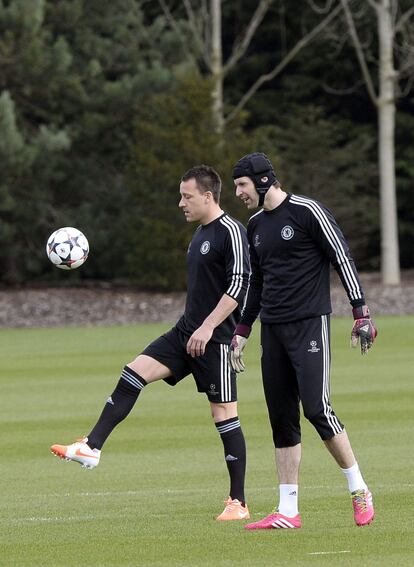 El portero del Chelsea Peter Cech (dcha) y su compañero John Terry asisten al entrenamiento del equipo en Cohbam en Surrey (Reino Unido) hoy, lunes 17 de marzo de 2014.