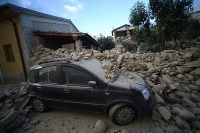 Um veículo coberto de escombros na cidade de Amatrice.