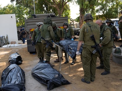Los soldados israelíes transportan un cadáver en el kibutz de Kfar Aza, este martes.