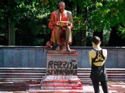 Una mujer hace una foto de la estatua de Indro Montanelli en Milán, atacada con pintadas que lo acusan de racista y violador.