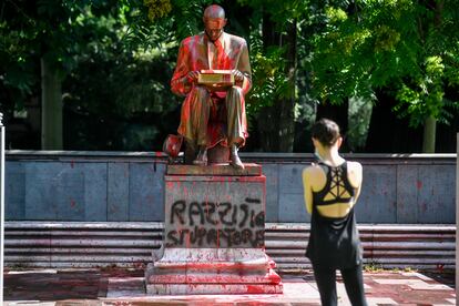 Una mujer hace una foto de la estatua de Indro Montanelli en Milán, atacada con pintadas que lo acusan de racista y violador.