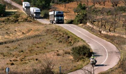 Un motorista de la Guardia Civil abre paso, ayer por la tarde, a los camiones a su paso por la aldea de Los Herreros.