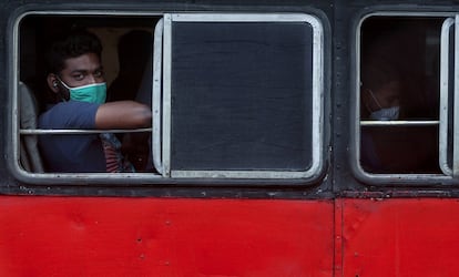 Un hombre mira por la ventanilla de un autobús que se detiene en Dharavi, uno de los barrios marginales más grandes de Asia, en Bombay (la India).