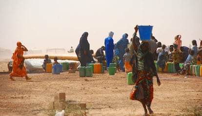 Mujeres y niños hacienda cola para coger agua en el campamento de Mentao, en Burkina Faso.