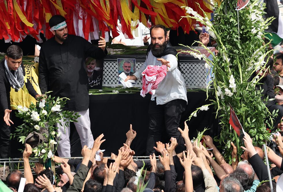 Varias personas se reúnen en torno a los ataúdes del difunto dirigente político de Hamás, Ismail Haniya, y de su guardaespaldas, durante el cortejo fúnebre, este jueves en Teherán (Irán). 