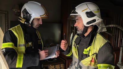 Dos bomberos evalan los da?os en la casa en la que han fallecido por hombres a causa de un incendio en Mstoles.