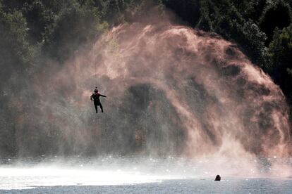 Un soldado desciende desde un helicóptero para rescatar a una persona en el agua, en Kunming (China). 