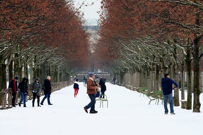 La gente camina por el jardín de las Tullerías de París cubierto de nieve.