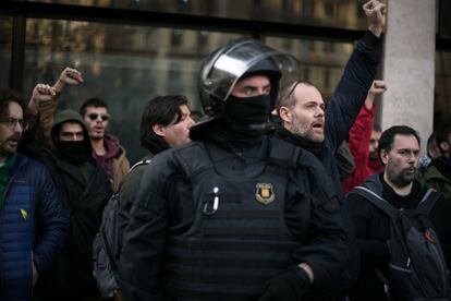 Activistas de los CDR protestan detrás de un 'mosso' durante la huelga general en Cataluña.