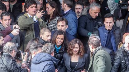 La presidenta de la Comunidad de Madrid, Isabel Díaz Ayuso, rodeada por miembros de su equipo a la salida de un acto en la Complutense en enero de 2023.