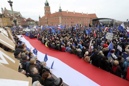 Un grupo de gente sostienen un bandera gigante de Polonia durante la manifestación a favor de la Unión Europea.