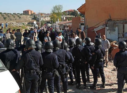 Un centenar de vecinos del poblado chabolista más grande de Madrid, la Cañada Real Galiana, en el que viven 30.000 personas, ha plantado cara a la orden de derribo de una vivienda ilegal de ladrillo. Y lo han hecho con todo lo que tenían a mano: piedras, ladrillos, botellas y hasta bombonas de butano. En la foto, numerosos efectivos custodian la casa ya derruida.