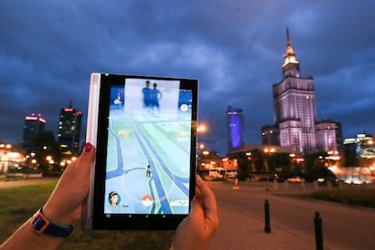 Una joven juega con la aplicaci&oacute;n Pokemon Go cerca al Palacio de la Ciencia y la Cultura de Varsovia (Polonia)