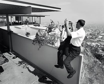 Julius Shulman, encaramado sobre el muro de la casa Stahl, con su ‘jardín portátil’.