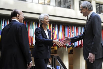 Christine Lagarde saluda al director en funciones del FMI, John Lipsky, en presencia de Shakour Shaalan, miembro del comité ejecutivo, ayer en la sede de la institución, en Washington.