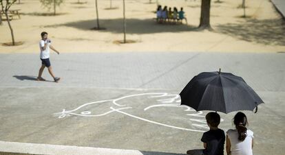 Alumnos de un colegio de Sevilla se resguardan del calor durante el recreo.