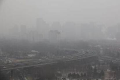 Coches circulan entre la densa niebla por una carretera de Pekín, China. EFE/Archivo