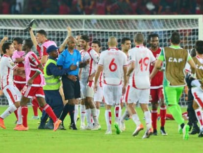 El &aacute;rbitro Rajindraparsad Seechurn se aleja del terreno de juego increpado por los jugadores tunecinos.