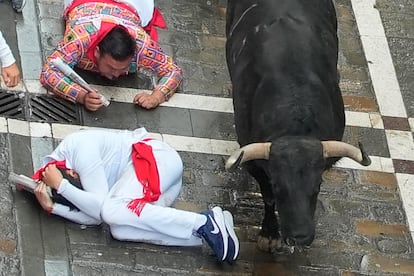 Varios corredores caen al suelo durante el primer encierro.

