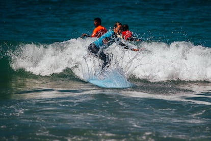 Una turista española surfea su primera ola durante una clase de surf en Praia do Norte. 
