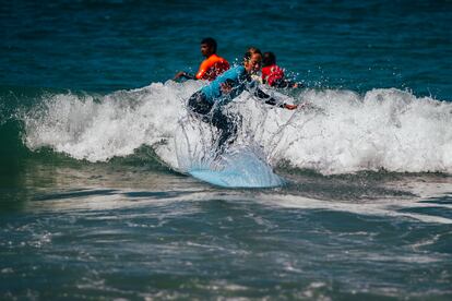 Una turista española surfea su primera ola durante una clase de surf en Praia do Norte. 
